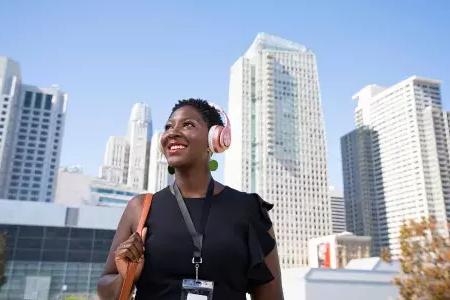 A woman wearing headphones walks through 贝博体彩app's SoMa neighborhood.